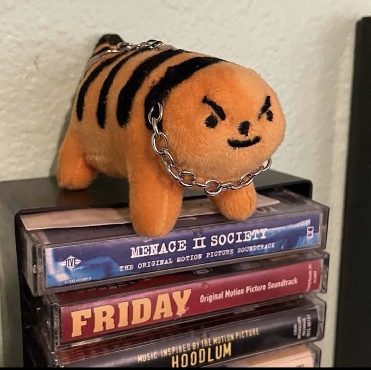 MF Cheeto Tiger plush wearing a chain on stacked cassette tapes